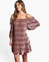 A woman modeling an off-the-shoulder, long-sleeve mini dress with a textured, vertically pleated pattern in dusty rose and mauve tones, set against a plain white studio background.