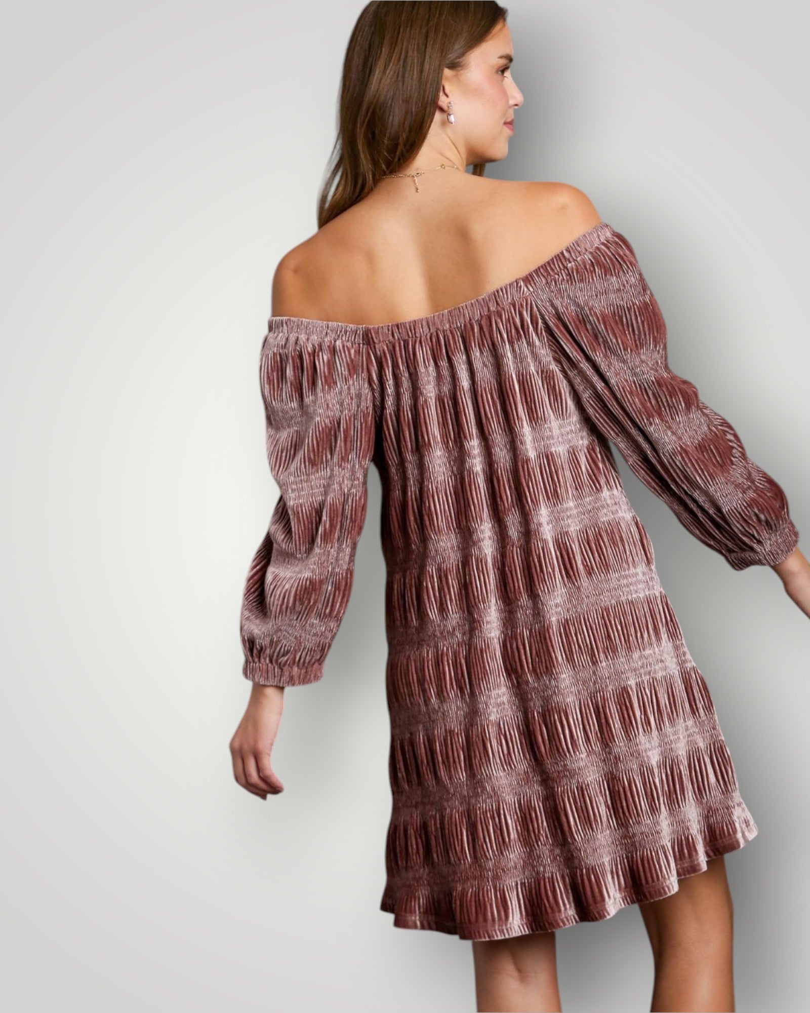 Woman wearing a patterned off-shoulder dress against a plain background