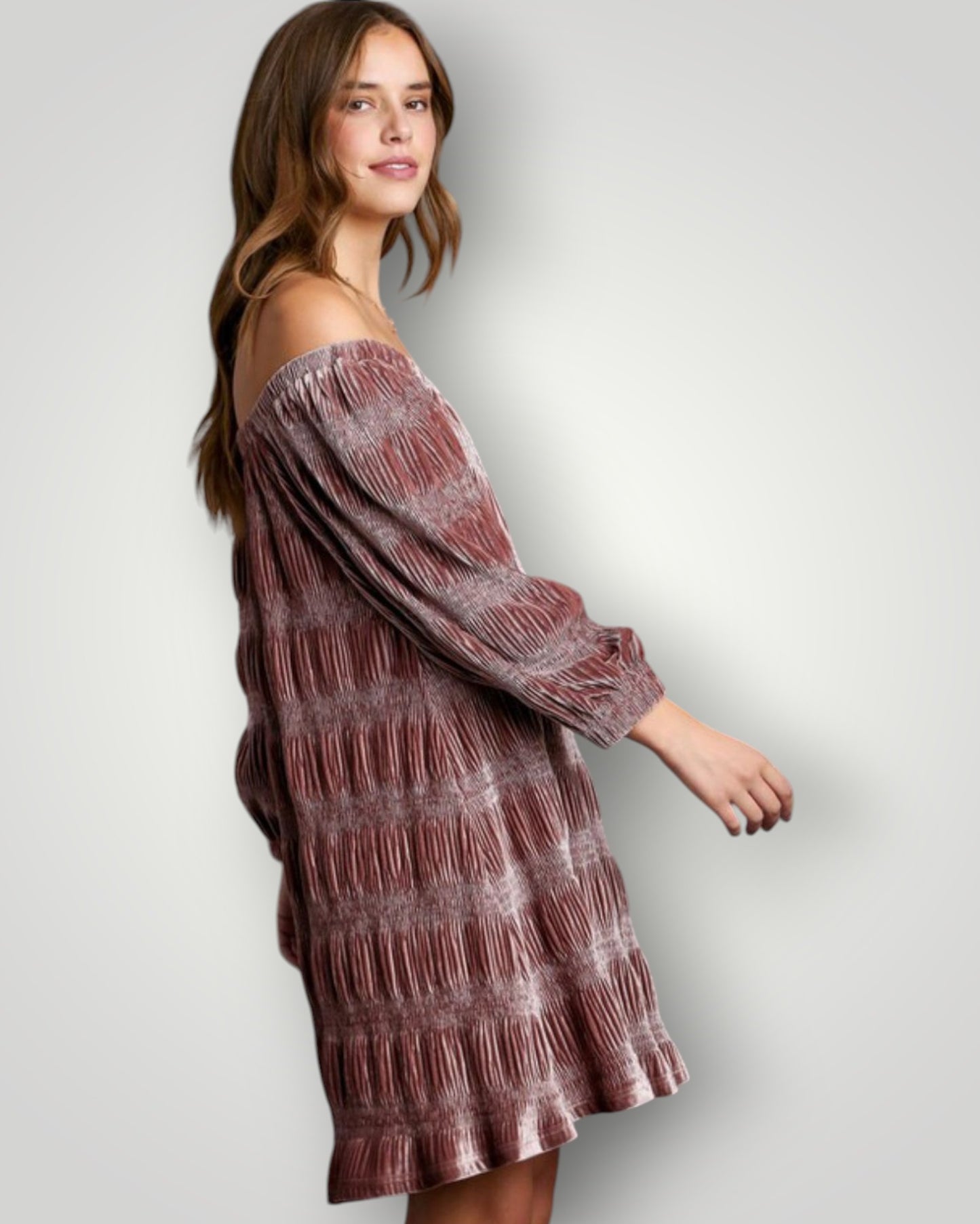 Woman wearing a patterned off-shoulder dress against a plain background