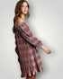 Woman wearing a patterned off-shoulder dress against a plain background