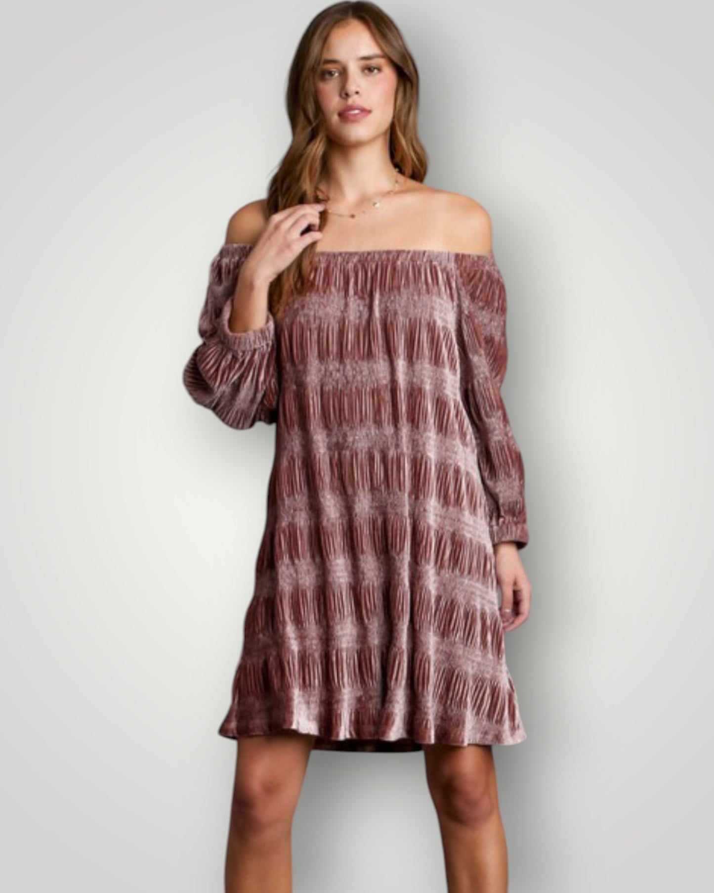 Woman wearing a patterned off-shoulder dress against a plain background