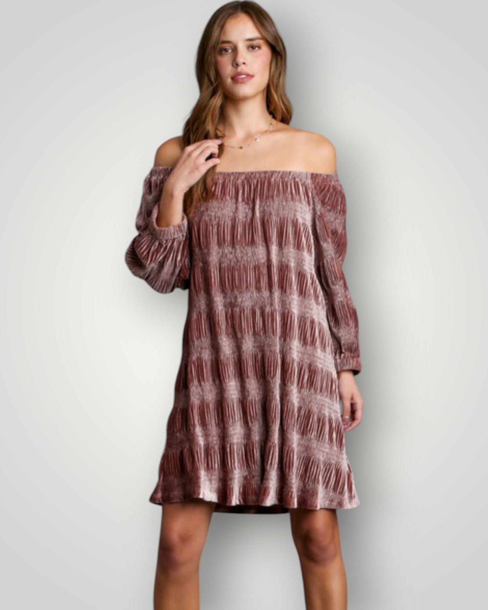 Woman wearing a patterned off-shoulder dress against a plain background