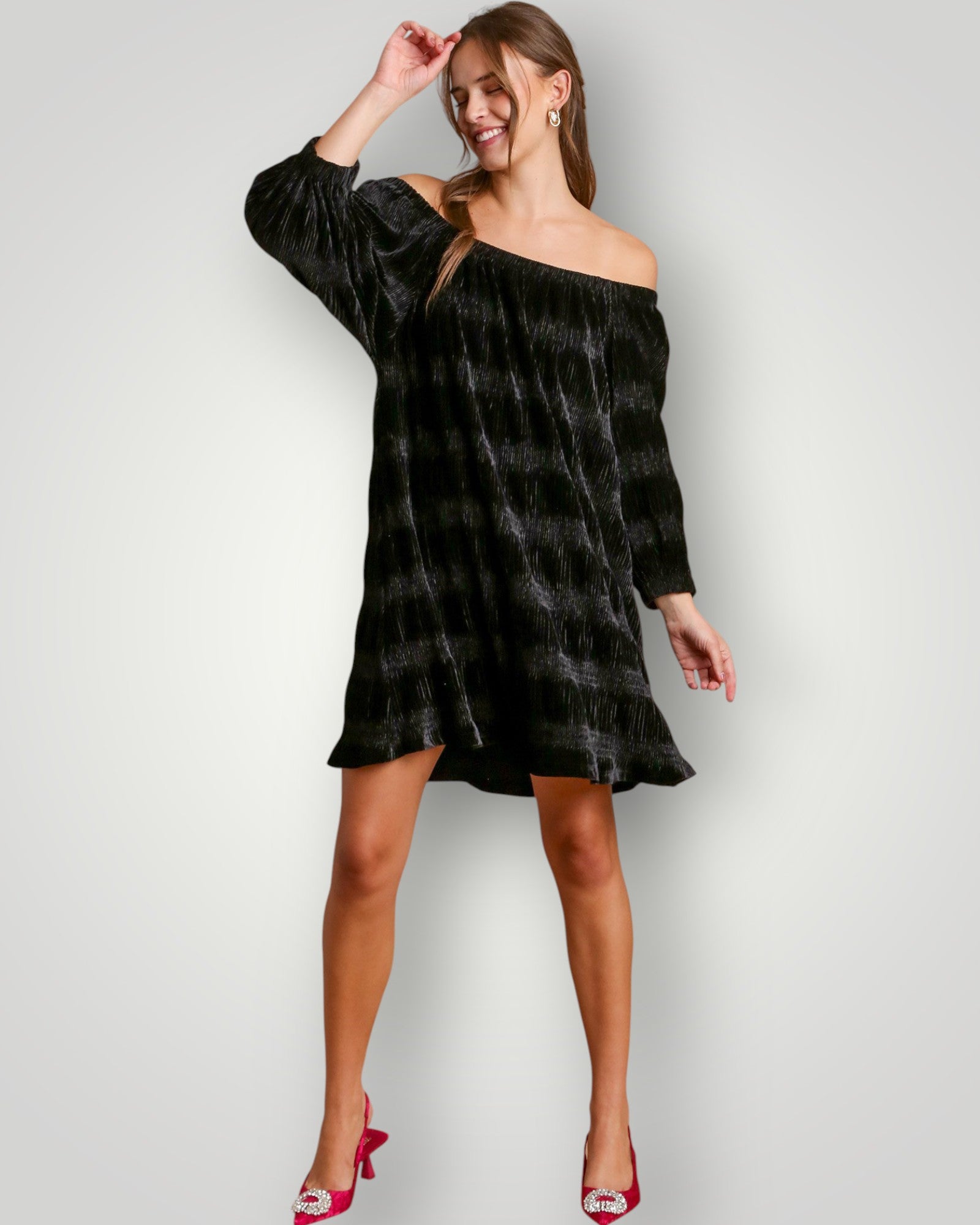 Woman wearing a black off-shoulder dress on a white background