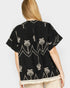 Black embroidered shirt with palm tree design on a white background