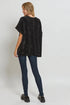 Woman wearing a black oversized sweater and dark jeans on a white background