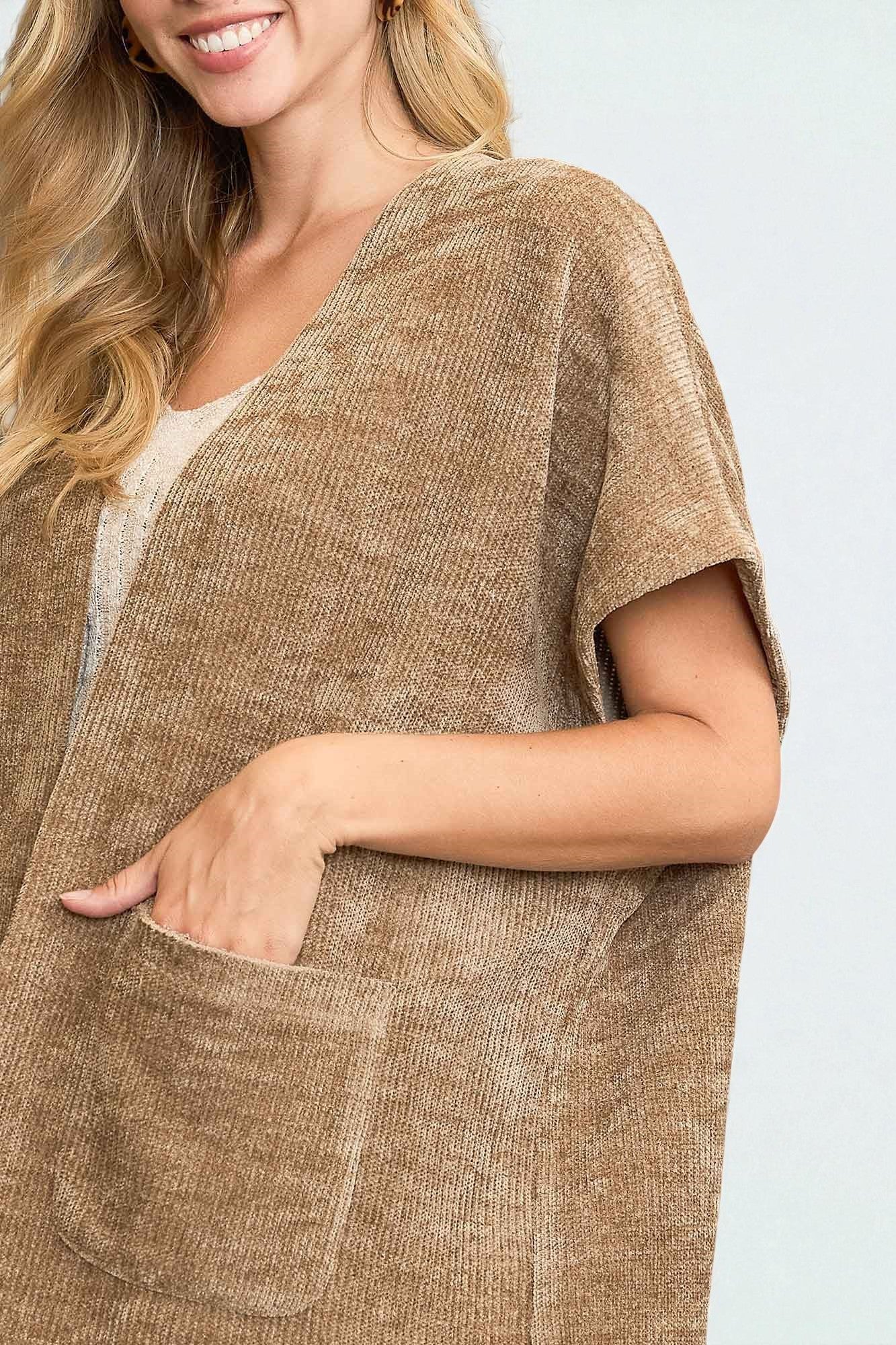 Woman wearing a brown textured cardigan on a light background