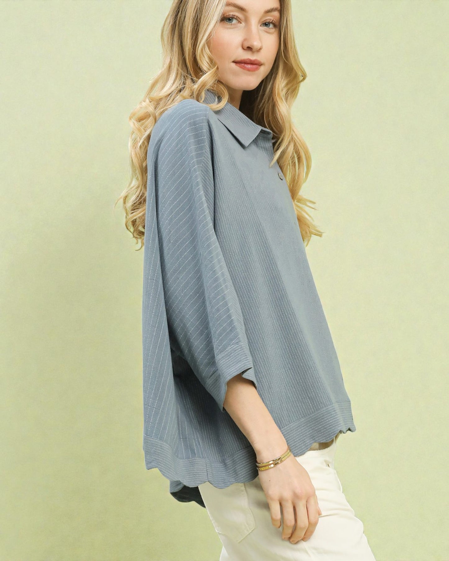 Woman wearing a light blue blouse against a green background