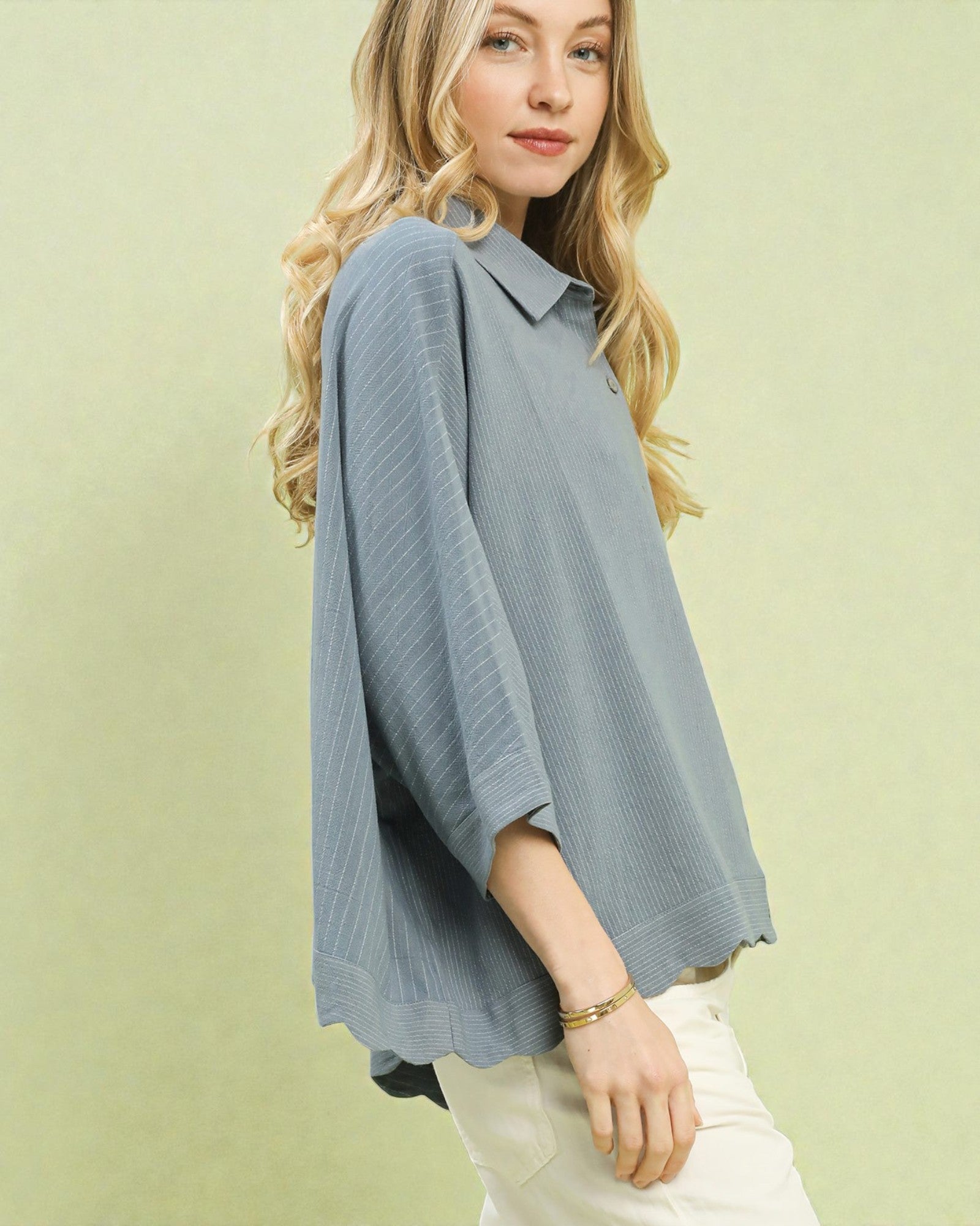 Woman wearing a light blue blouse against a green background