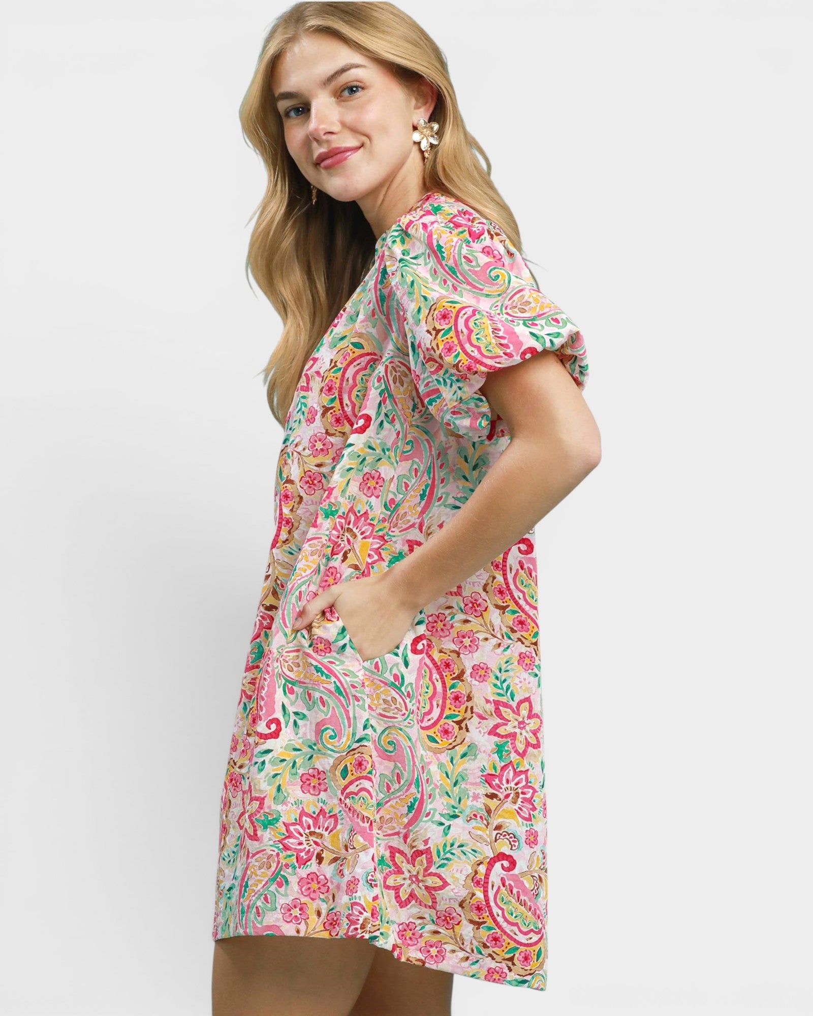 Woman wearing a colorful floral dress on a white background