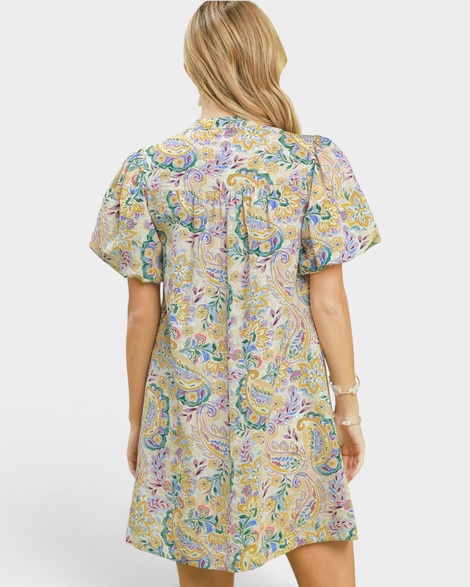 Woman wearing a colorful patterned dress on a white background