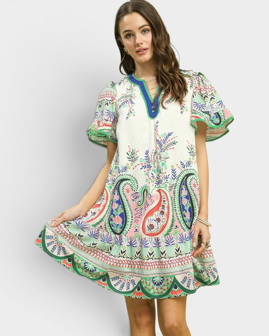 Woman wearing a colorful embroidered dress on a white background