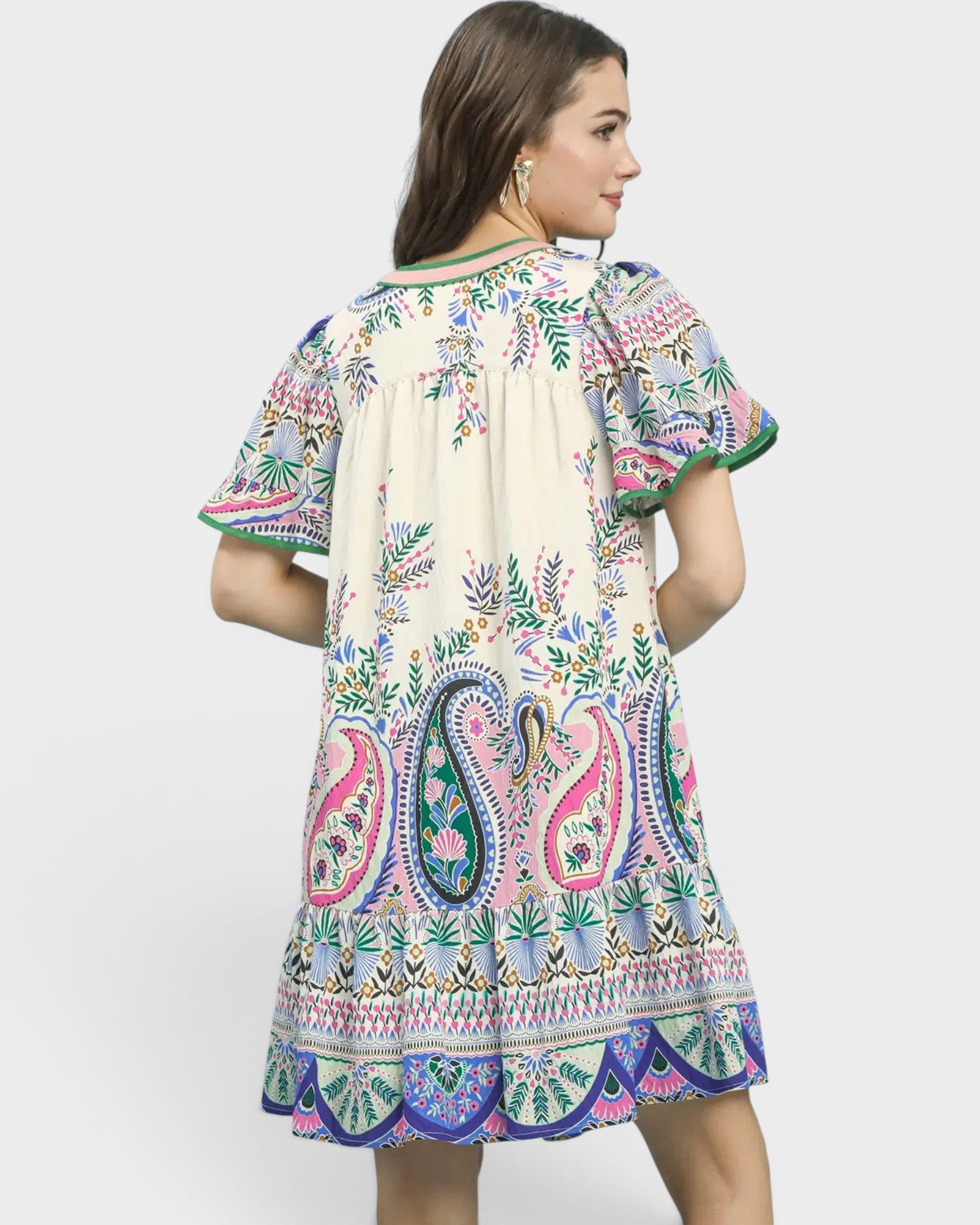 Woman wearing a colorful patterned dress on a white background