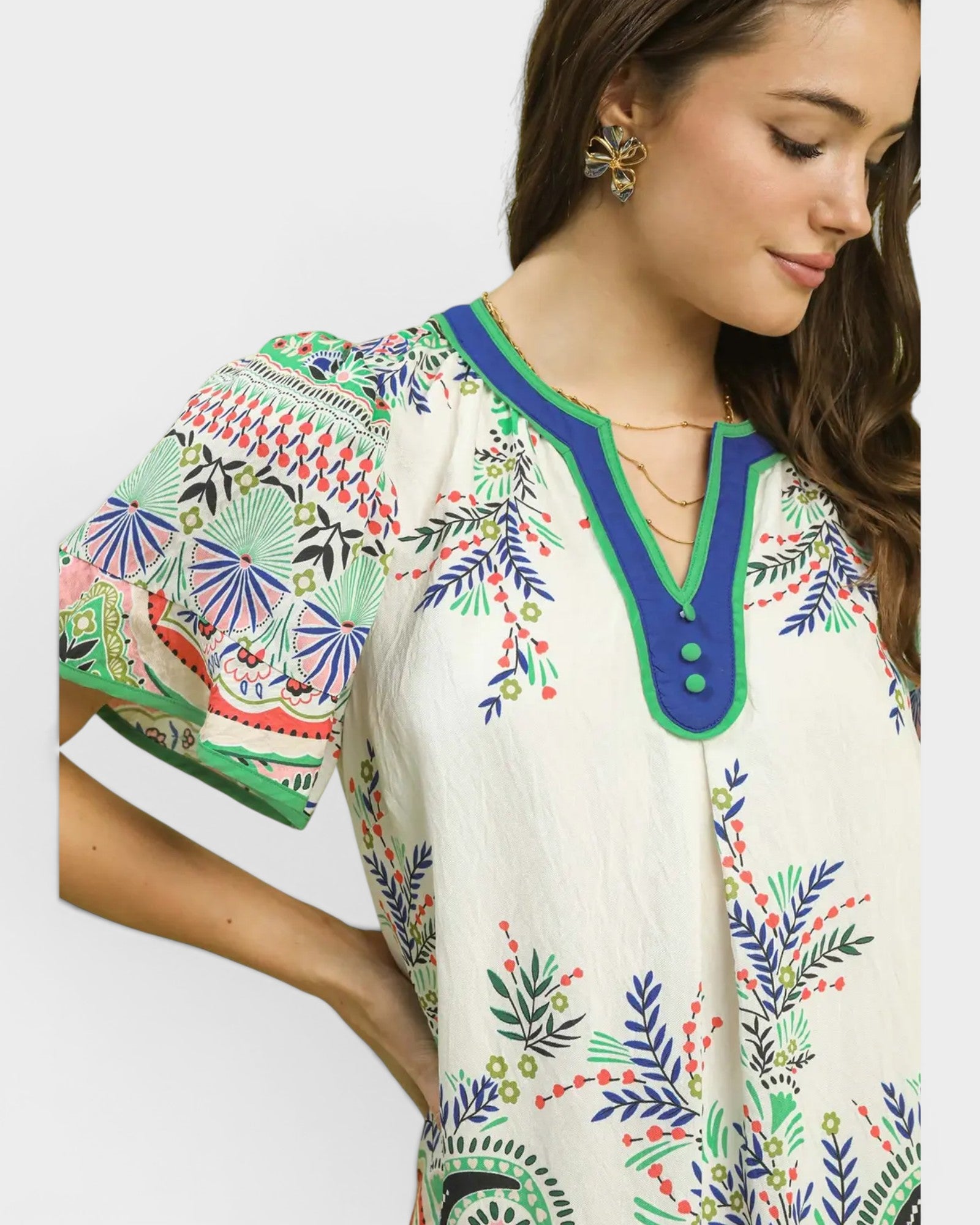 Woman wearing a colorful embroidered blouse on a white background