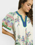 Woman wearing a colorful embroidered blouse on a white background