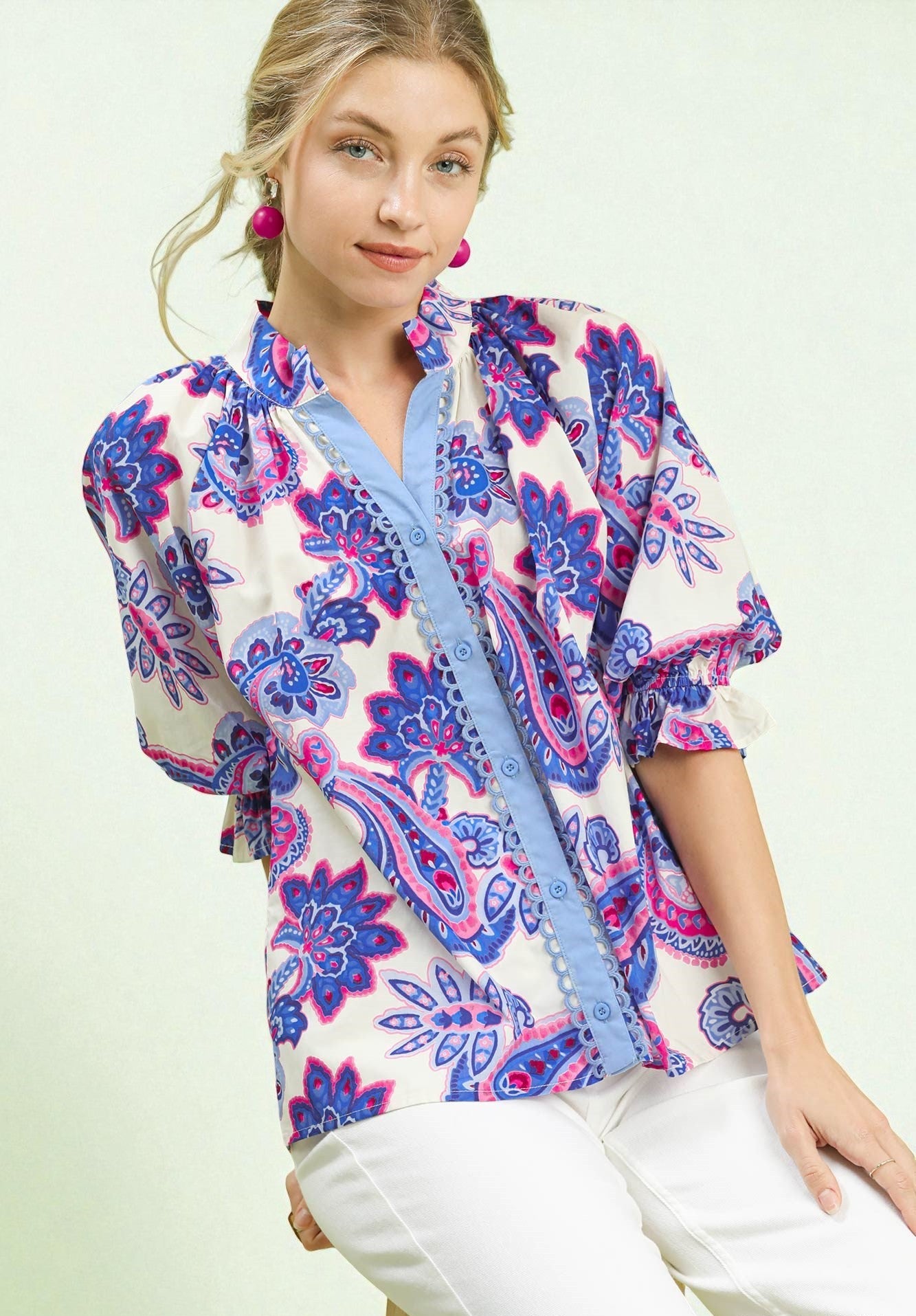 Woman wearing a colorful patterned blouse with a white background