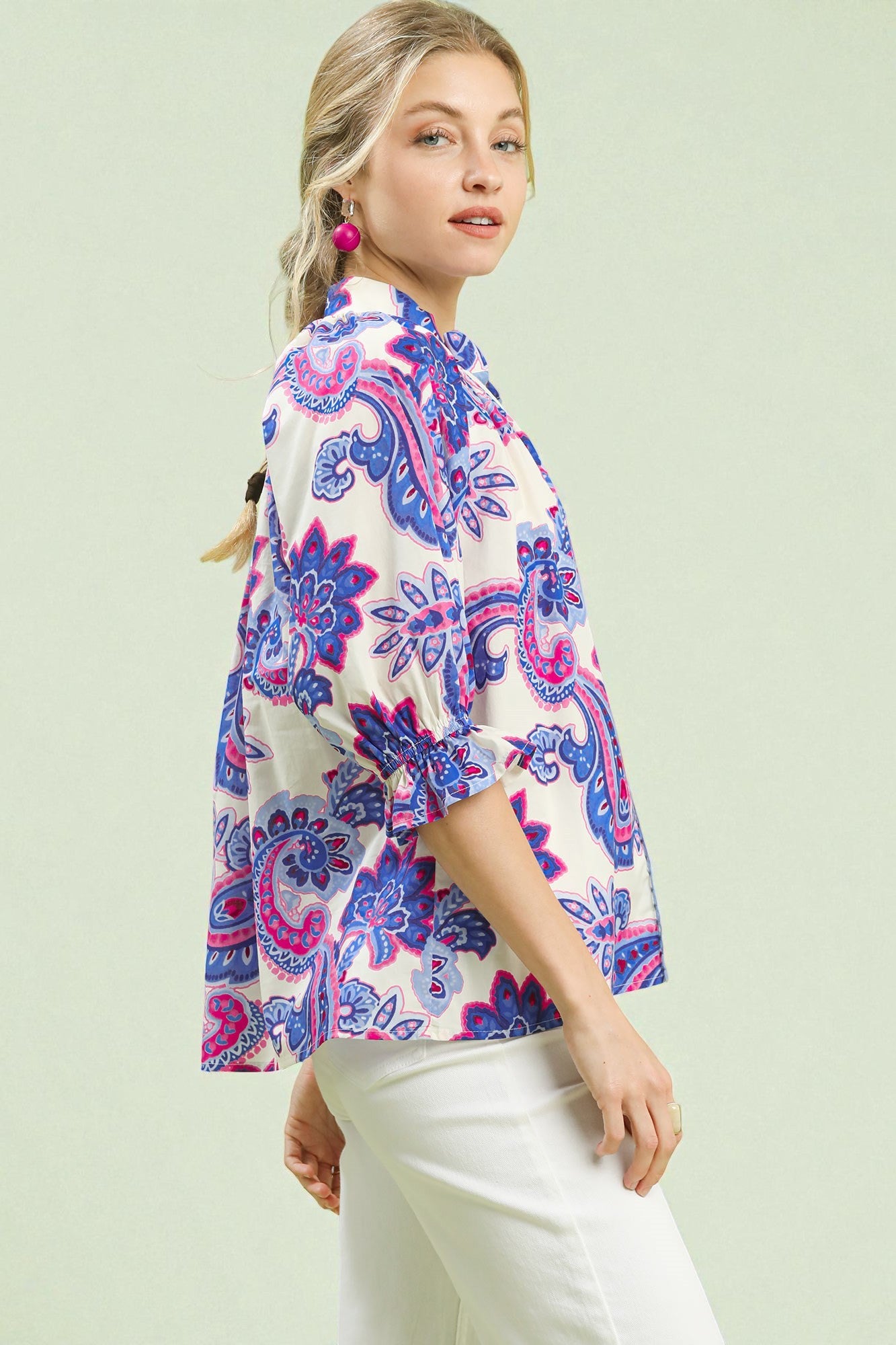 Woman wearing a colorful floral kimono-style top on a light green background