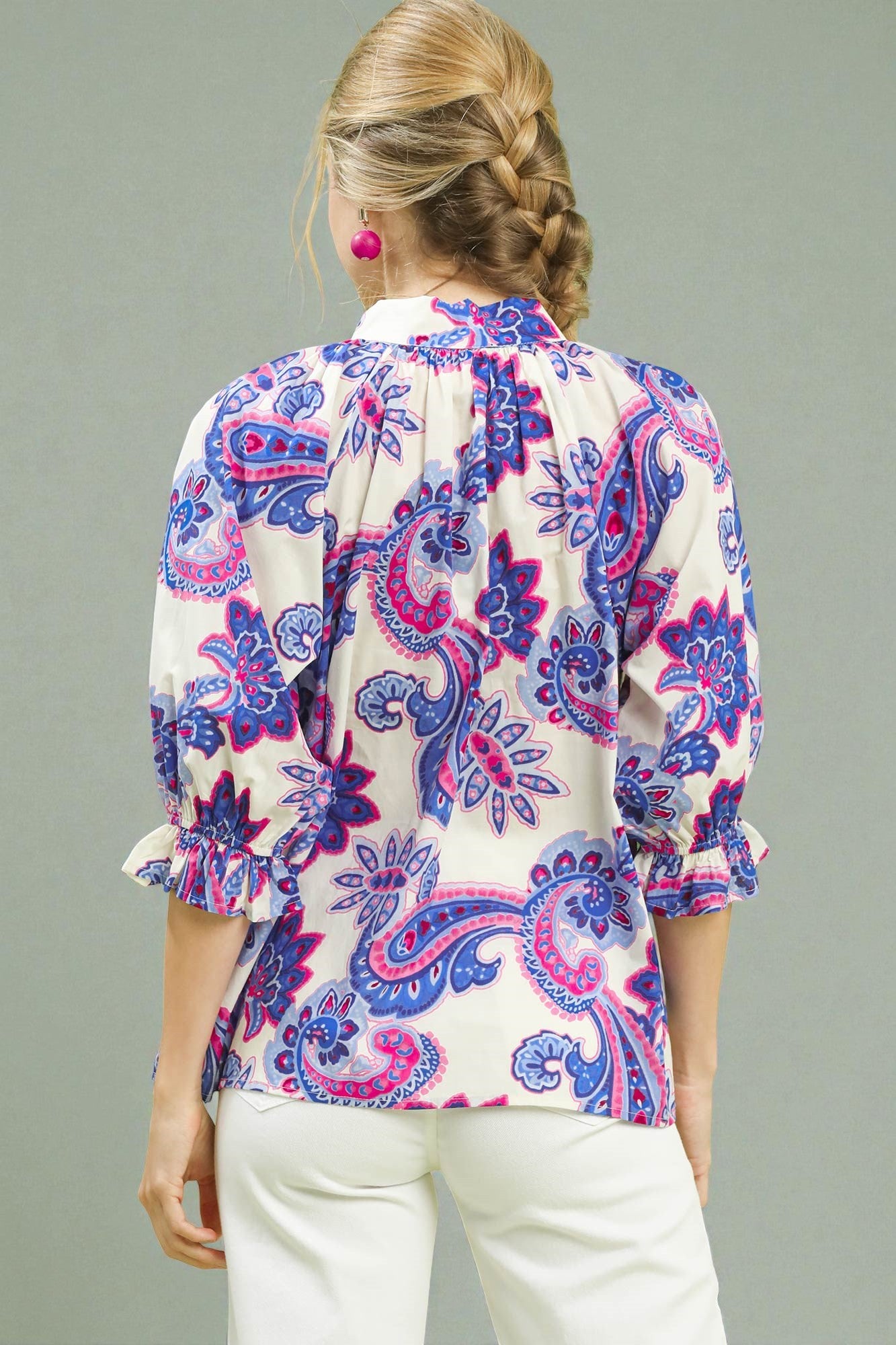 Woman wearing a patterned blouse with a gray background