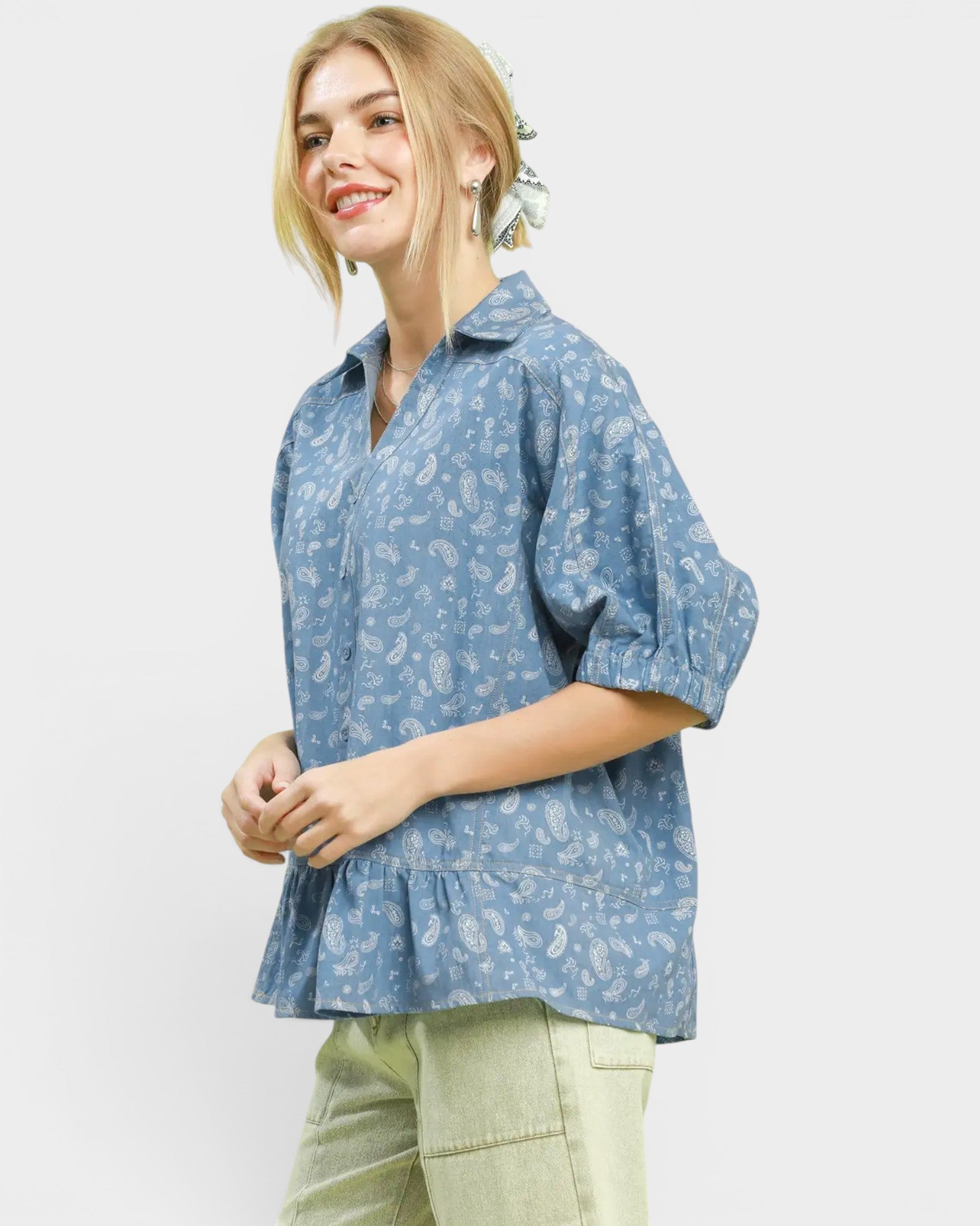 Woman wearing a blue floral blouse with a plain background