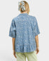 Person wearing a blue patterned shirt with a white background