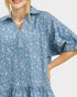 Woman wearing a blue patterned dress on a white background