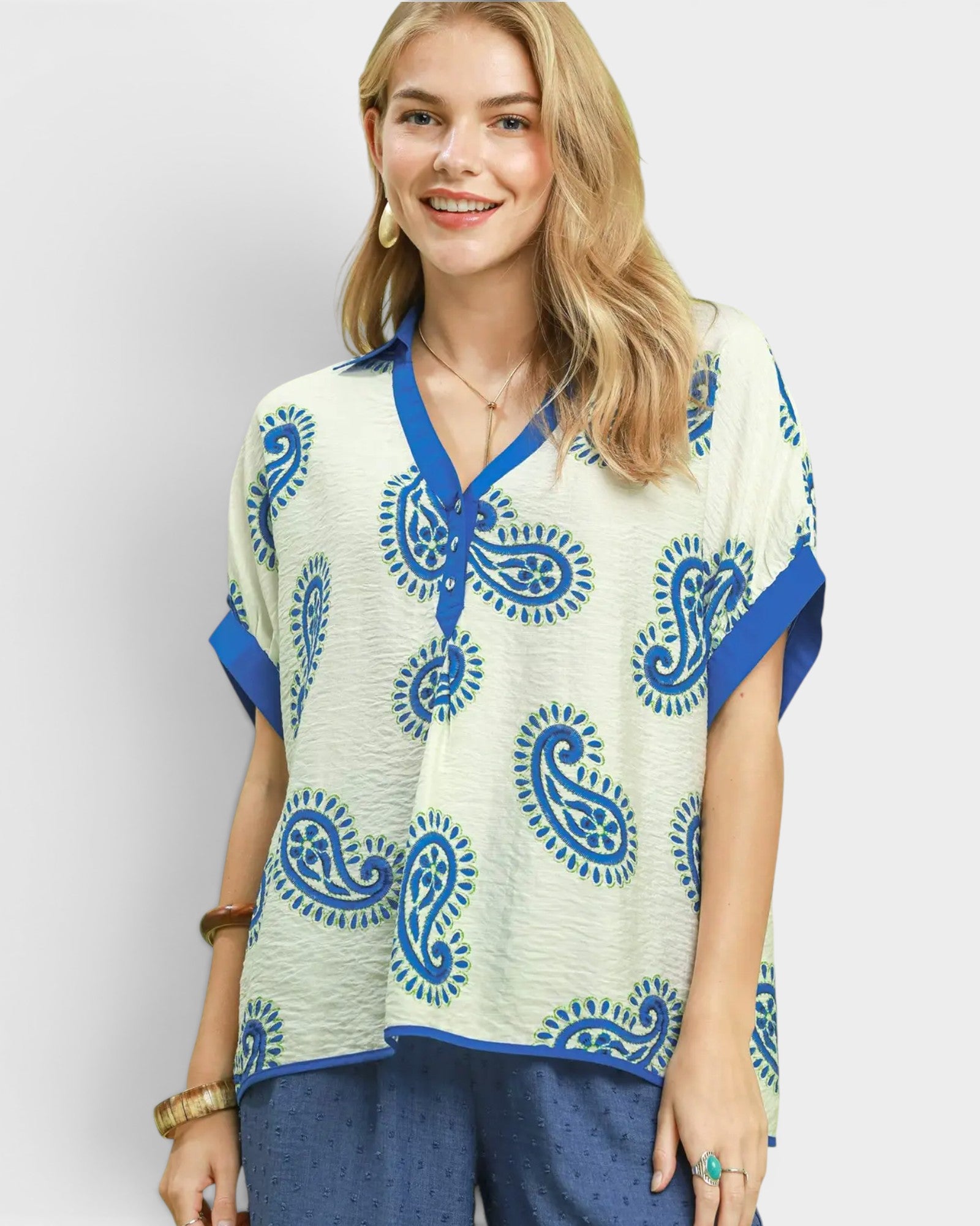 Woman wearing a blue and white patterned top on a plain background