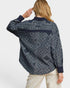 Person wearing a dark patterned shirt with a white background