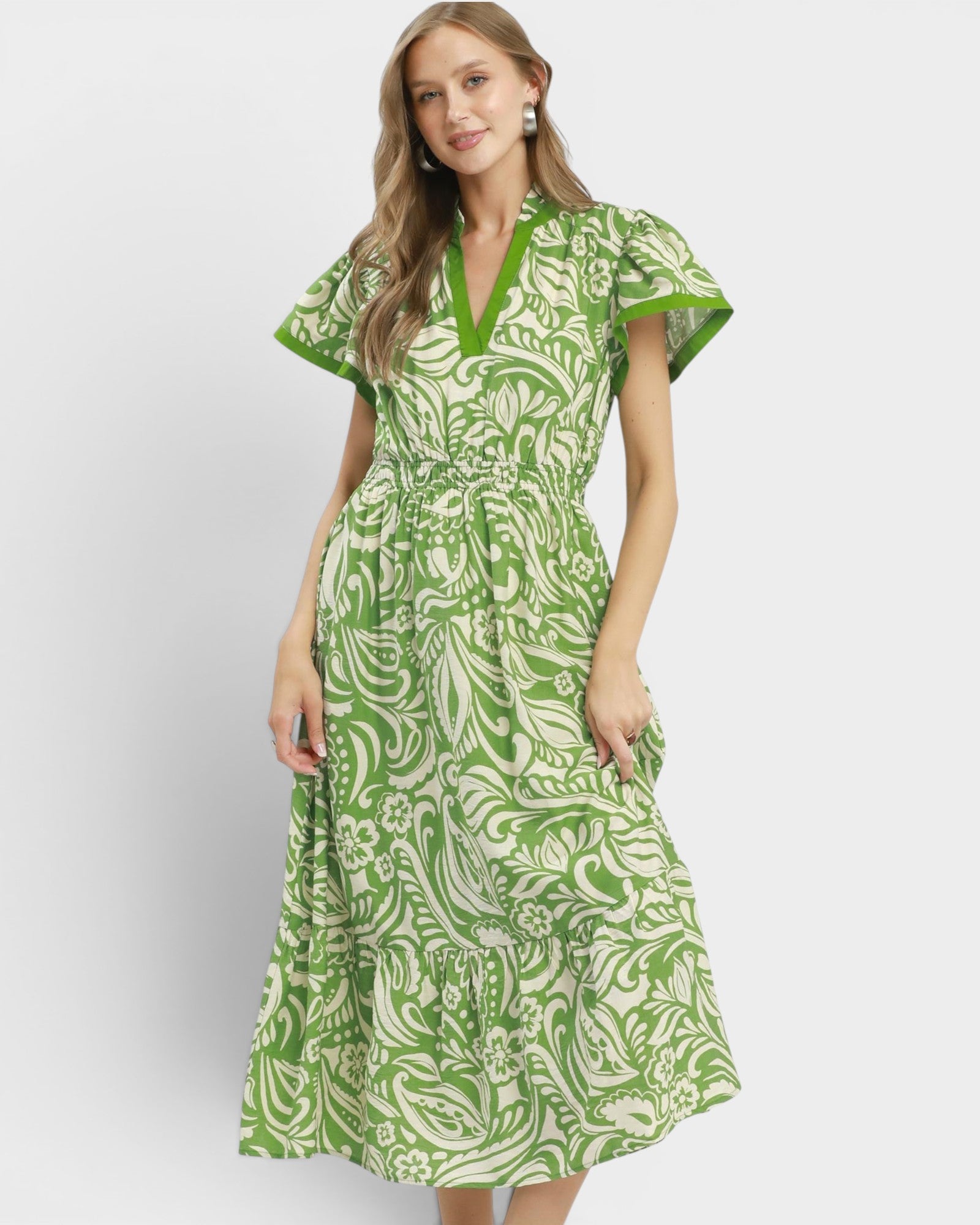 Woman wearing a green and white patterned dress on a white background