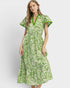 Woman wearing a green and white patterned dress on a white background