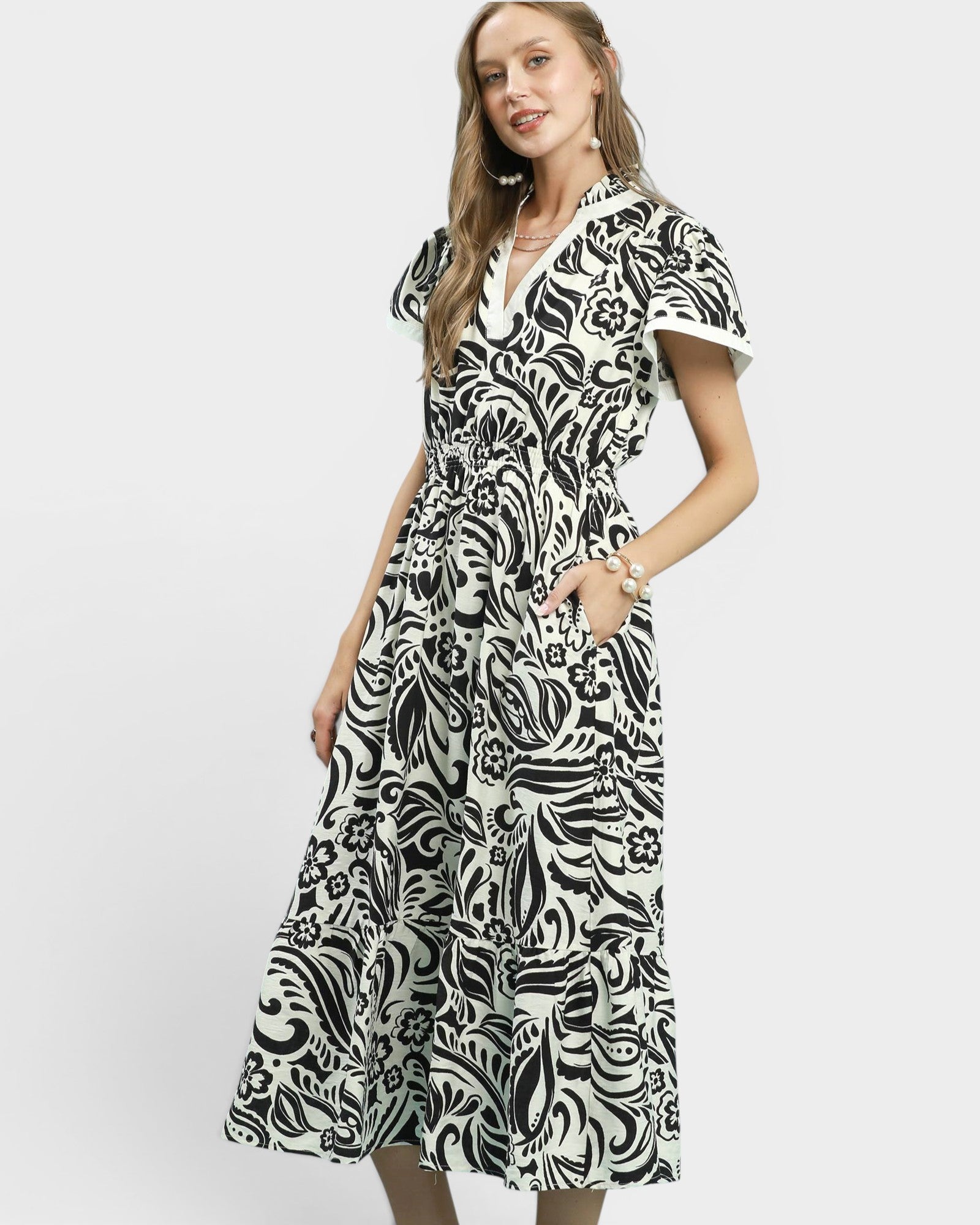 Woman wearing a black and white patterned dress on a white background