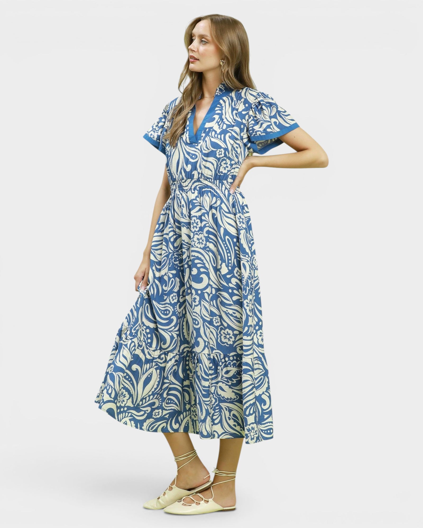 Woman wearing a blue and white patterned dress on a white background