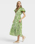 Woman wearing a green patterned dress on a white background