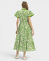Woman wearing a green and white patterned dress on a white background