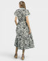 Woman wearing a black and white patterned dress on a white background
