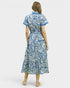 Woman wearing a blue and white patterned dress on a white background