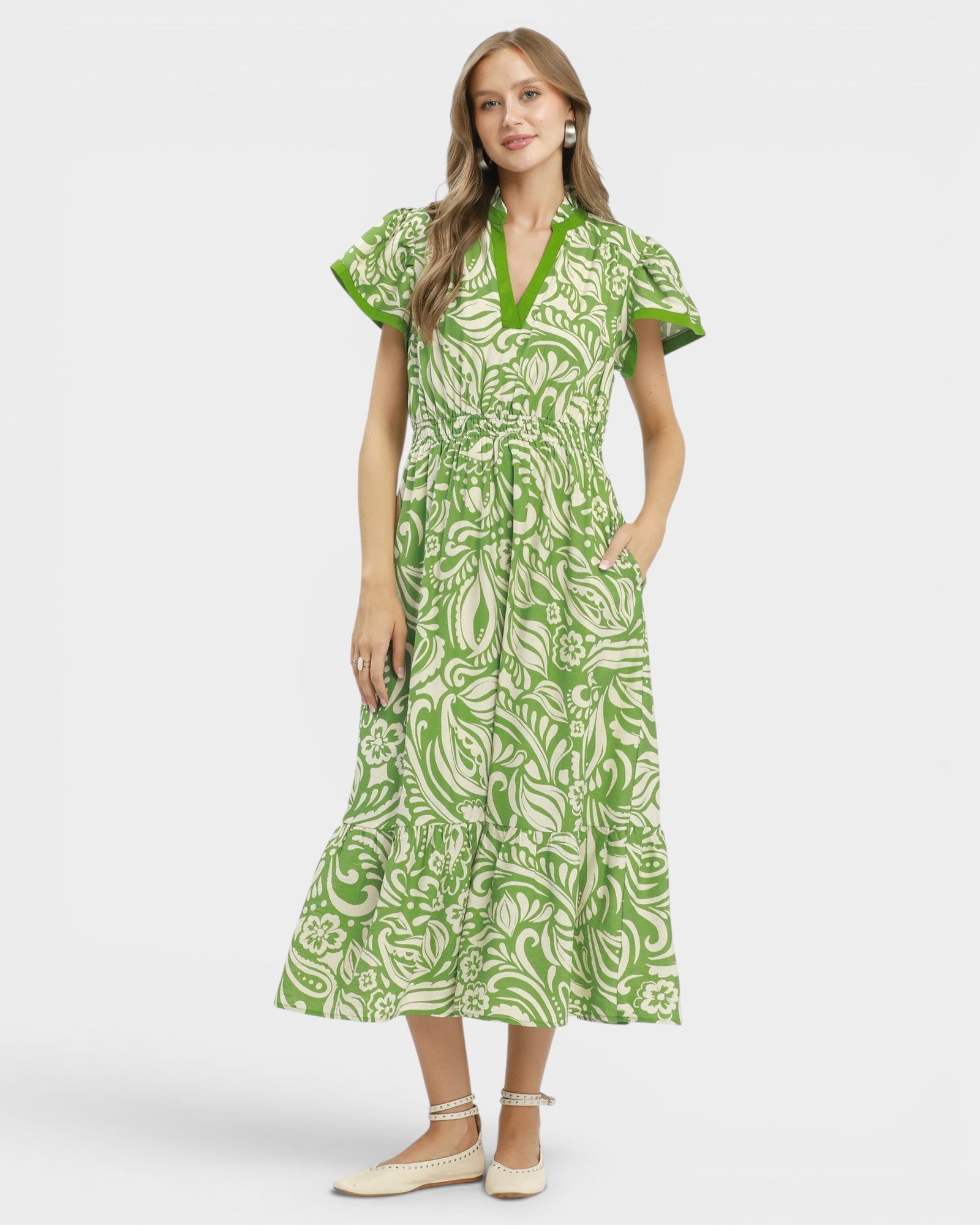 Woman wearing a green and white patterned dress on a white background