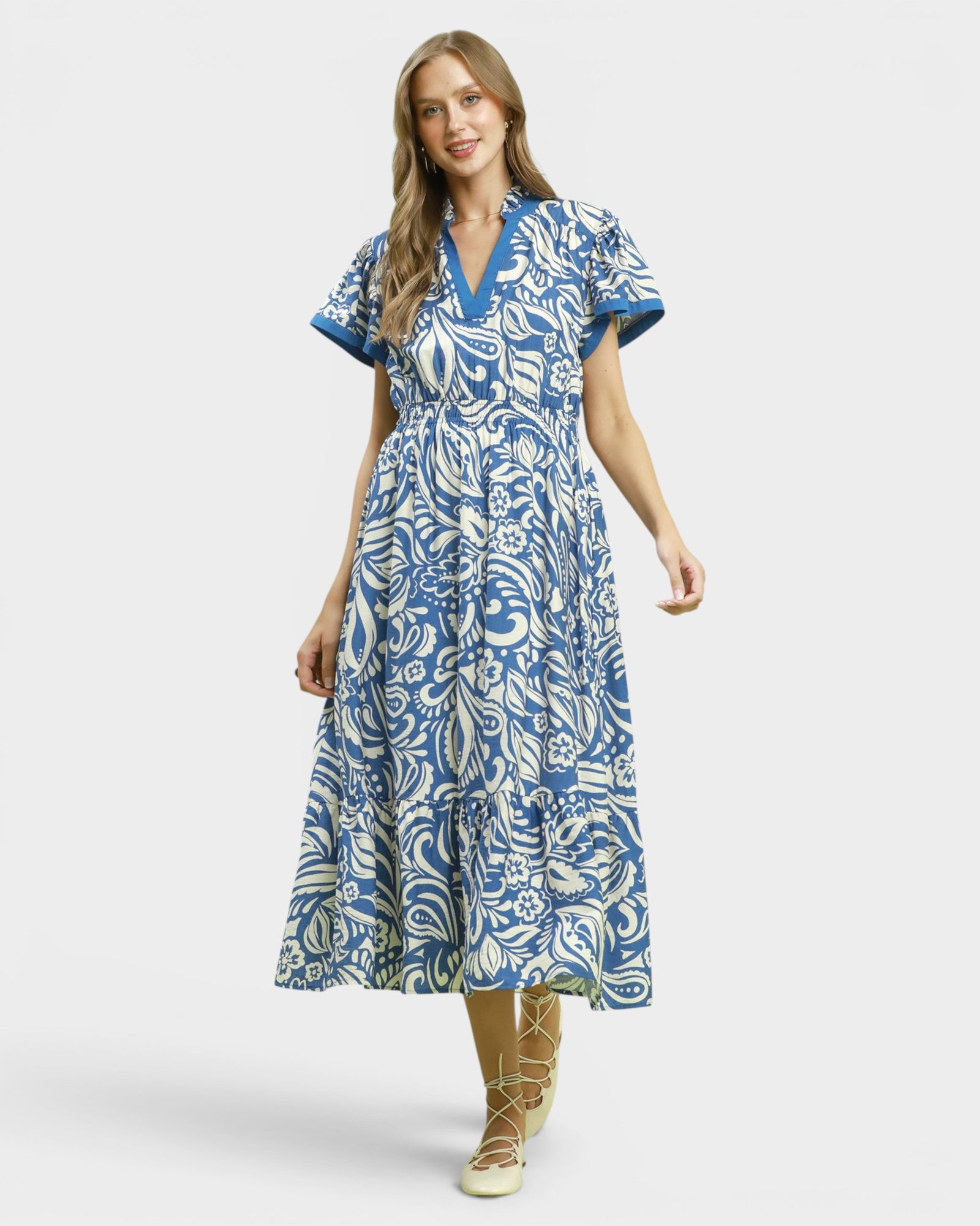 Woman wearing a blue and white patterned dress on a white background