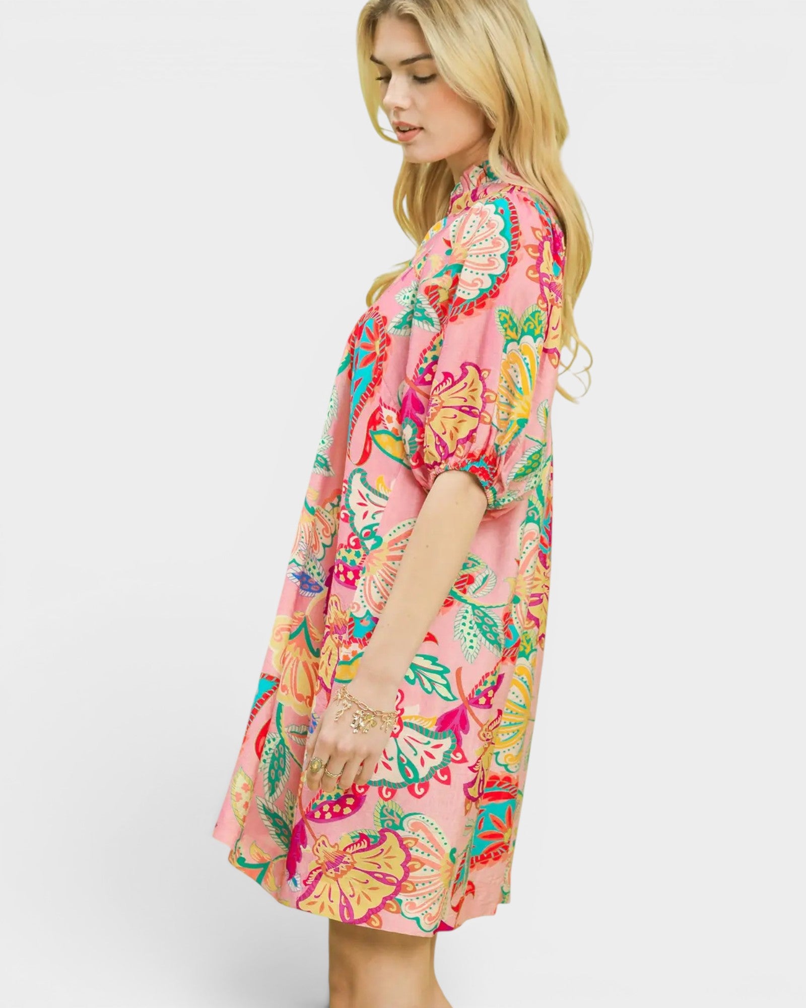Woman wearing a colorful floral dress on a white background