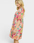 Woman wearing a colorful floral dress on a white background