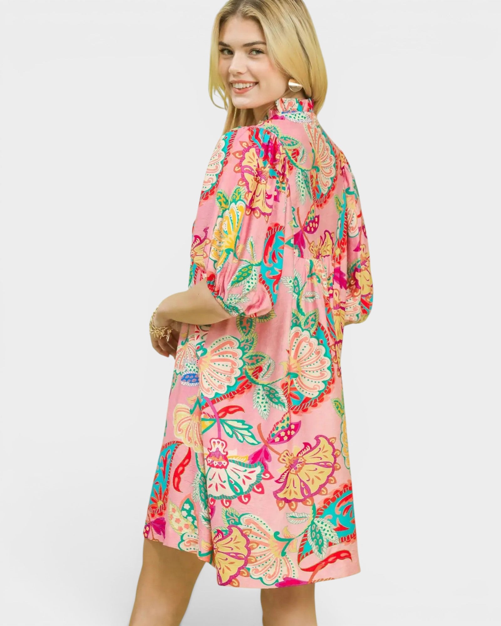 Woman wearing a colorful floral dress on a white background