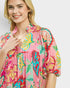 Woman wearing a colorful floral dress on a white background