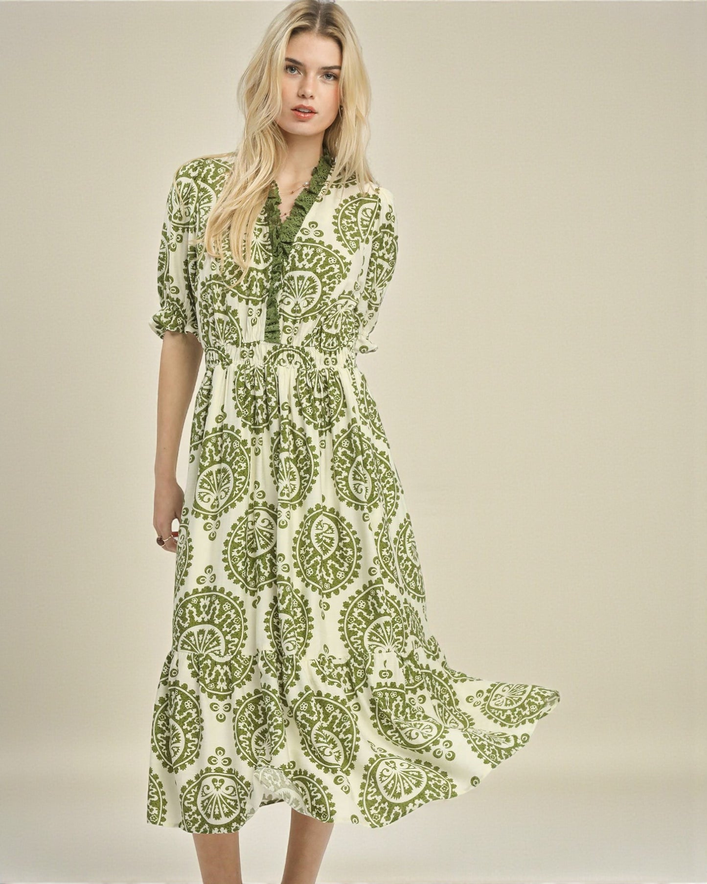 Woman wearing a green and white patterned dress on a beige background