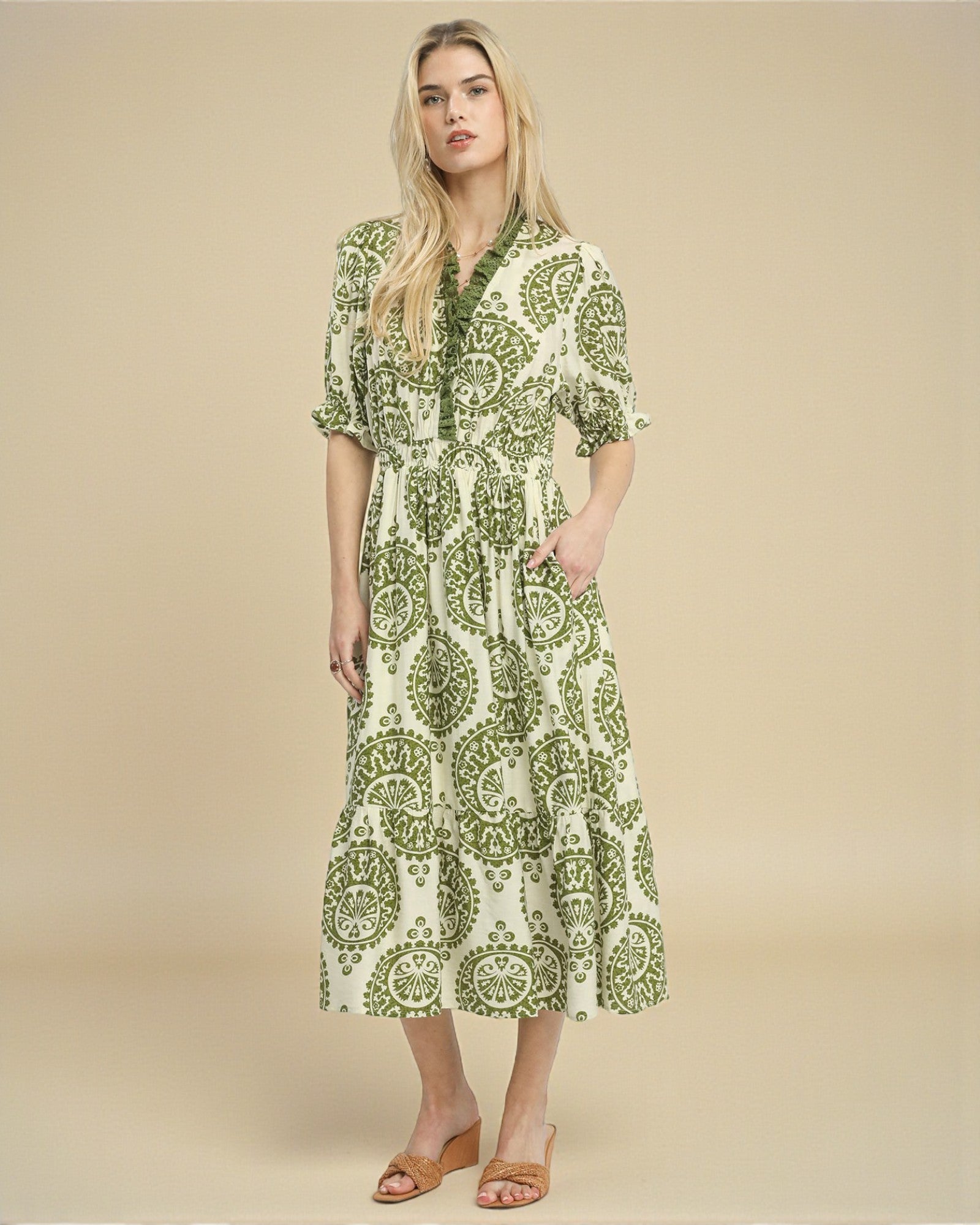 Woman wearing a green and white patterned dress on a beige background