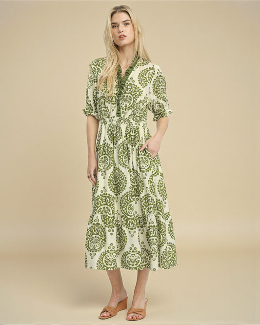 Woman wearing a green and white patterned dress on a beige background