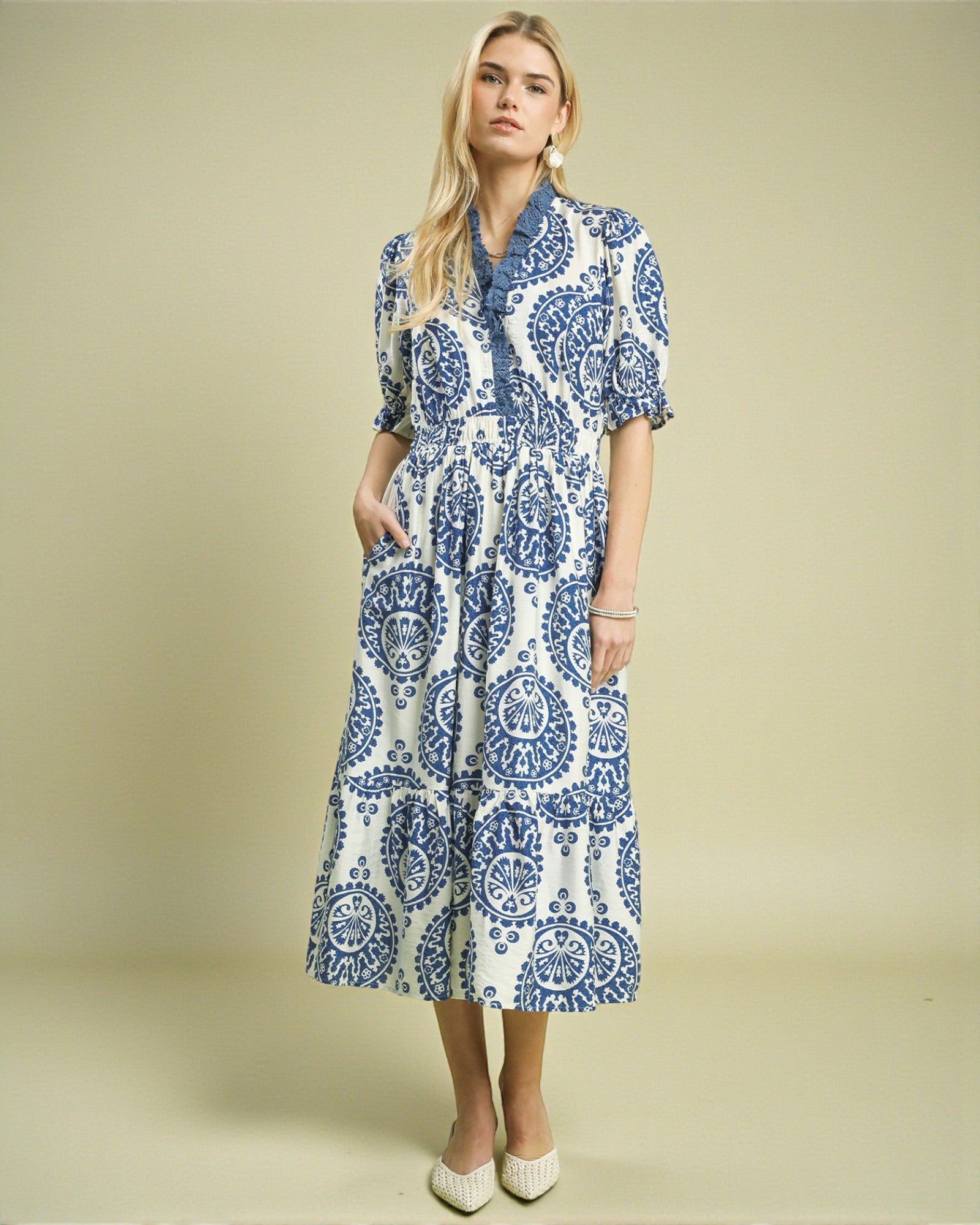 Woman wearing a blue and white patterned dress on a beige background