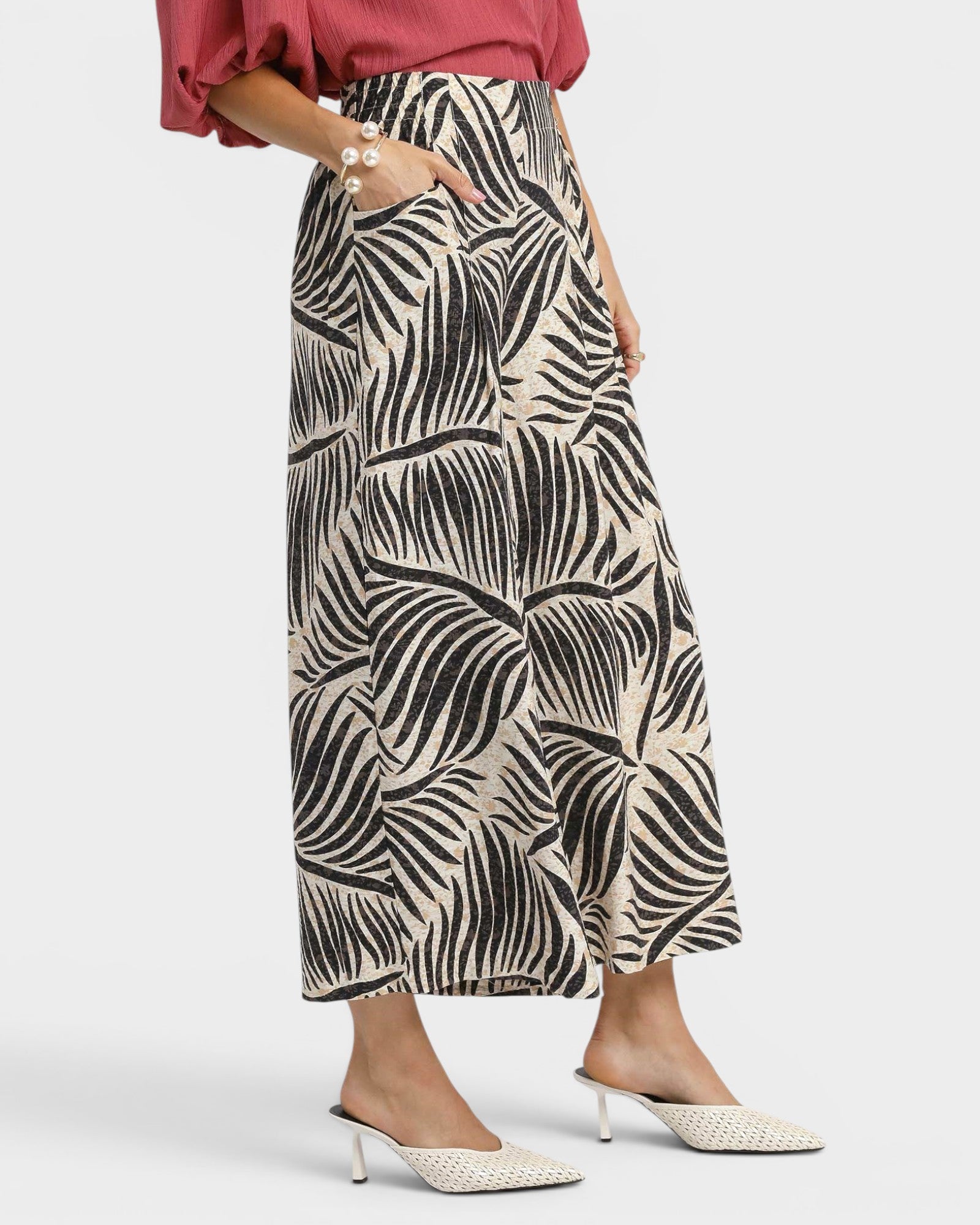 Person wearing a patterned skirt on a white background
