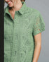 Green patterned shirt worn by a person on a gray background