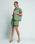 Woman wearing a green outfit on a plain background
