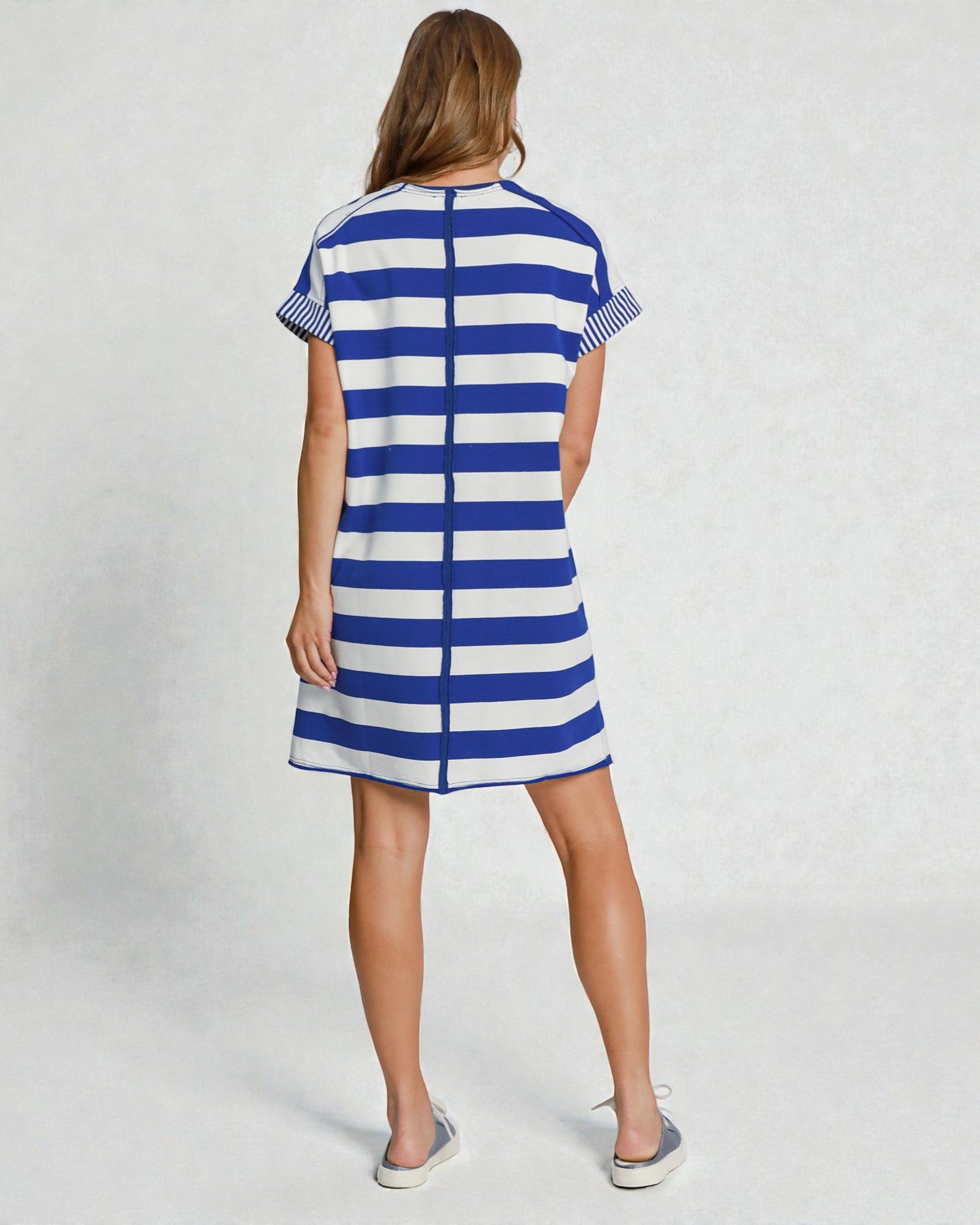 Woman wearing a blue and white striped dress on a plain background