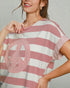 Woman wearing a pink and white striped shirt with a peace symbol design.