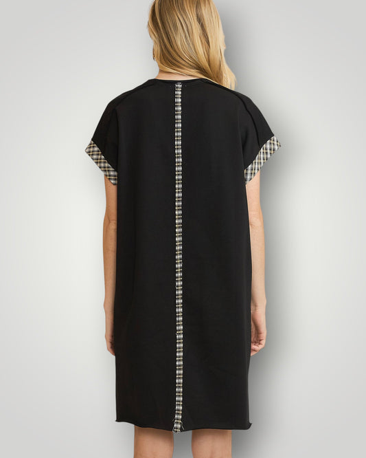 Black dress with plaid sleeves and trim on a plain background